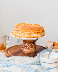 serve thin sweet pancakes on a wooden stand to pour honey, hands