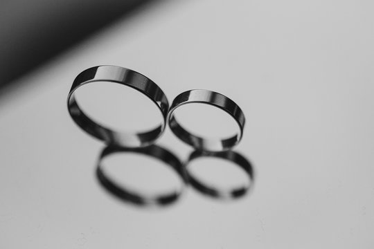Two wedding rings laying on a mirror. black and white photo