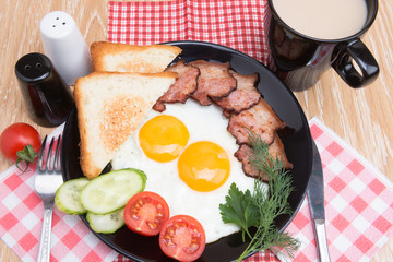 fried eggs with bacon on black dish