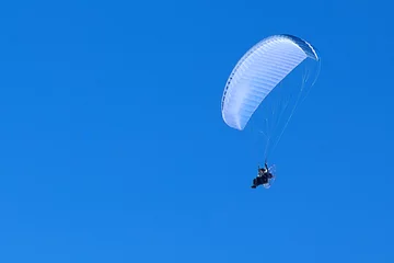 Cercles muraux Sports aériens powered paragliding in the blue sky