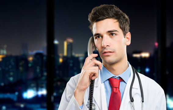 Young Doctor On The Phone At Late Night In His Studio