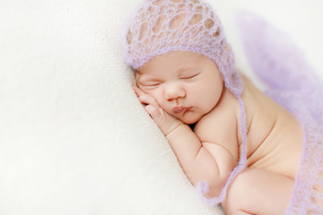 Fototapeta na wymiar Photo of a newborn baby curled up sleeping on a blanket