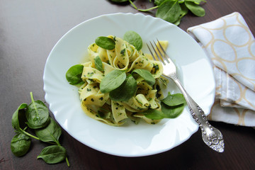 Italian pasta in spinach sauce and fresh leafs