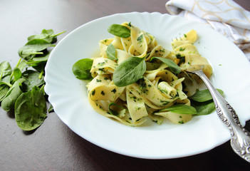 Pasta pappardelle with spinach leafs on white plate