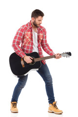 Man playing the black acoustic guitar