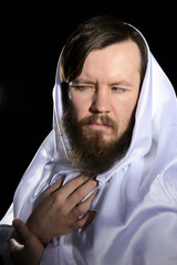 portrait of a bearded man in the studio in a white cloak