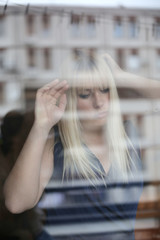Portrait of beautiful blonde through the glass