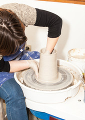 Fototapeta na wymiar Female Potter creating a earthen jar on a Potter's wheel
