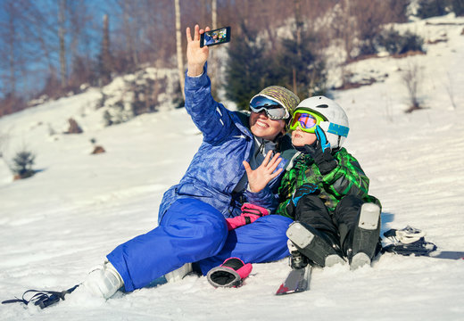 Mother and little son selfie on the ski slope resort
