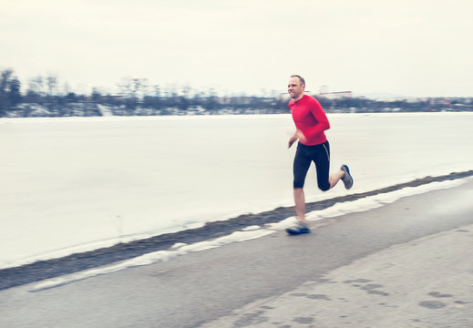 Man run near winter lake