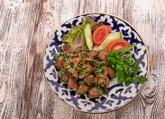 Fried meat with onion in a frying pan