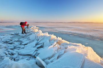 Photographer take pictures on the river bank in winter