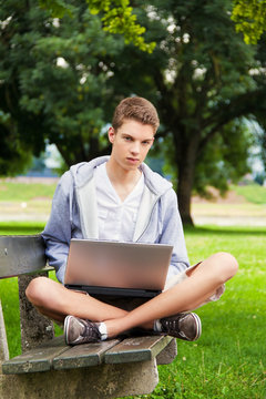 Teenager mit Laptop im Freien