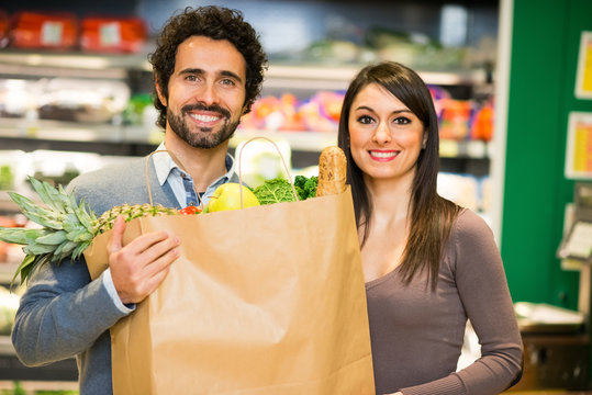 Young couple holding a shopping bag in a supermarket