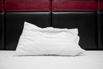 one white pillow on bed 