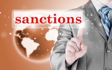 businessman pressing sanctions button on virtual screens