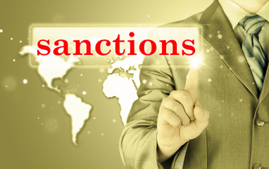 businessman pressing sanctions button on virtual screens