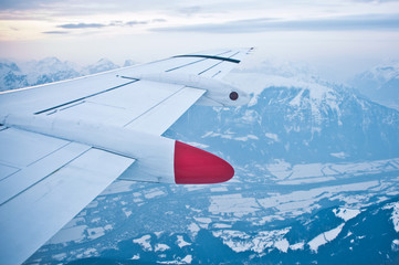 Naklejka na ściany i meble Flugzeug über scheebedeckten Alpen