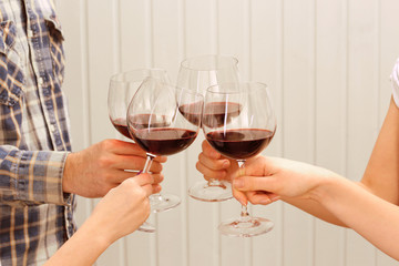 Clinking glasses of red wine in hands