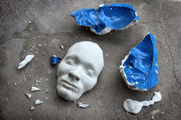 Plaster face mask between pieces of broken matt