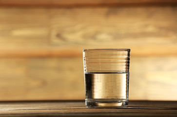 Glass of clean mineral water on rustic wooden background