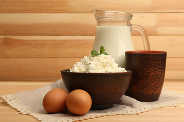 Cottage cheese in clay bowl with jug of milk and eggs