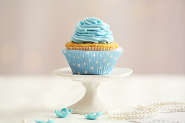 Sweet cupcake on table on light background