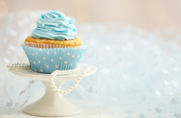 Sweet cupcake on table on light background