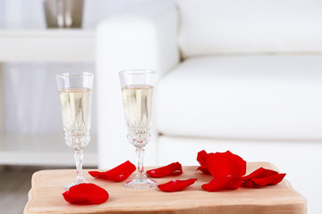 Champagne glasses and rose petals for celebrating Valentines