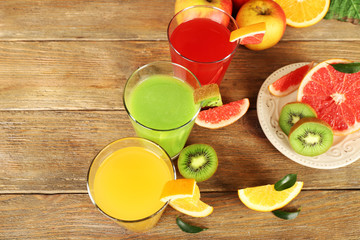 Fresh juices with fruits on wooden table