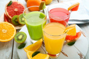 Fresh juices with fruits on wooden table