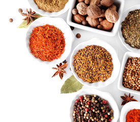 Different kinds of spices in ceramics bowls isolated on white