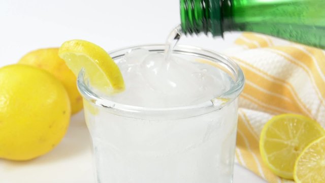 Pouring sparkling water with a slice of lemon