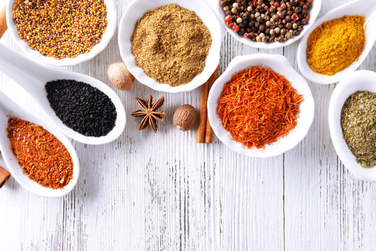 Different kinds of spices in ceramics bowls and spoons