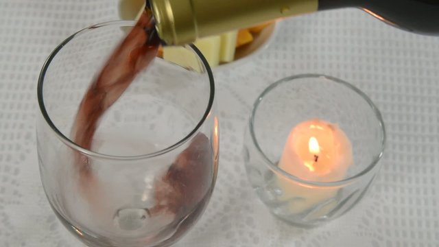Placing a candle on a table and pouring Burgundy wine