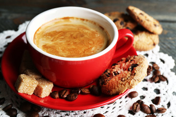 Cup of coffee and tasty cookies on wooden background