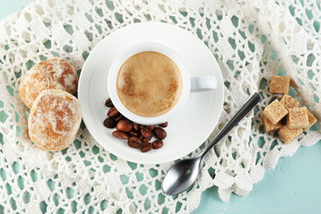 Cup of coffee and tasty cookie on color wooden background
