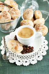 Cup of coffee and tasty cookie on color wooden background