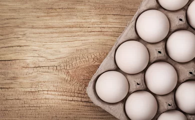 Fototapeten White eggs on wooden background © Guzel Studio