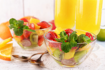 Fruit salad with mint and orange juice in glassware