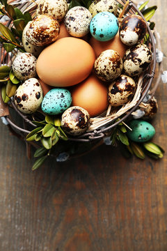 Bird eggs in wicker basket on  wooden background