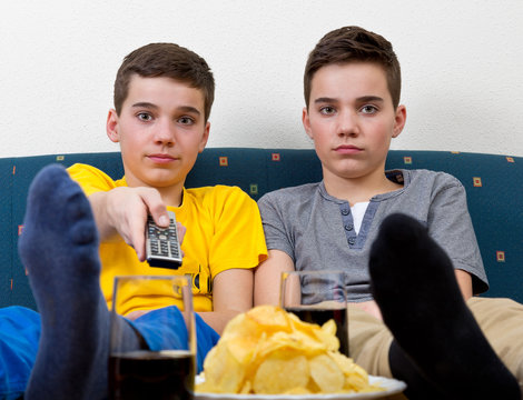 Zwei gelangweilte Jungen vor dem Fernseher