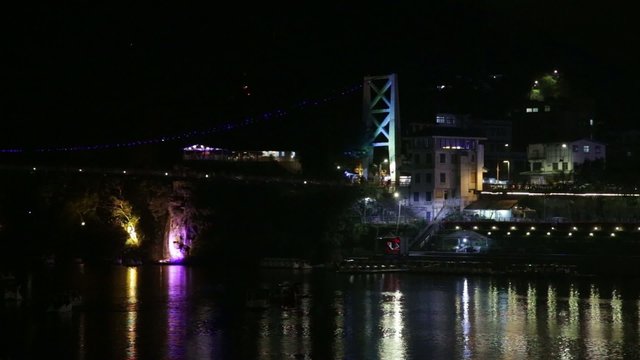 Night scene of lake with paddleboats, bridge and citylights 