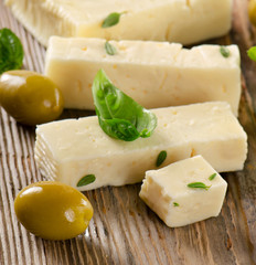 Feta cheese on  wooden cutting board.
