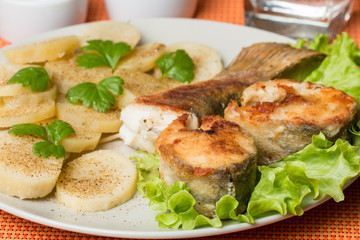 White fish with potato on white plat