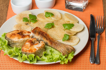 White fish with potato on white plat
