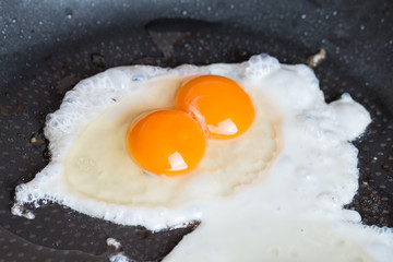 Close-up photo of two scrambled eggs in  pan