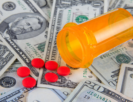 Pill box and pills on dollars