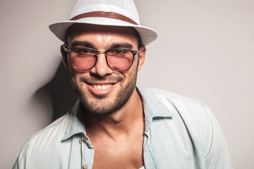 handsome casual man wearing a white hat and sunglasses.