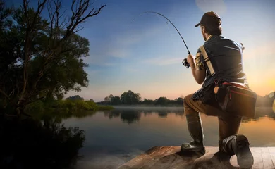 Meubelstickers Jonge man aan het vissen bij mistige zonsopgang © vitaliy_melnik